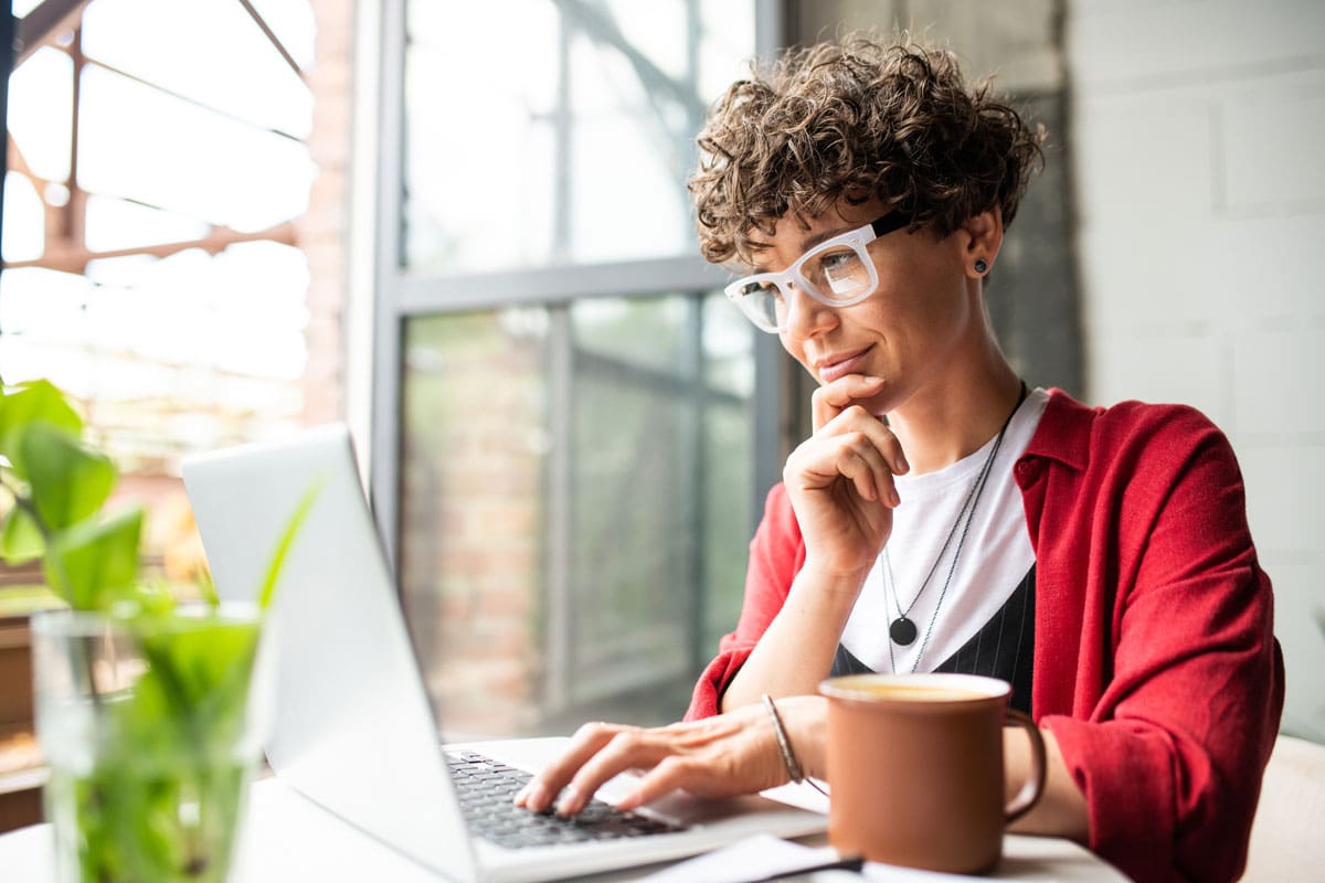 Woman wearing glasses working on laptop